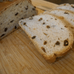 Slices of homemade cinnamon raisin bread on a cutting board.