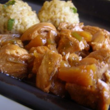 Serving of pineapple chicken on a black plate