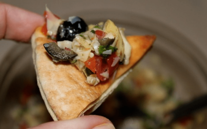 Prepared artichoke salsa on a pita chip
