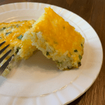 Slices of cheesy egg and rice bake on a cream colored plate